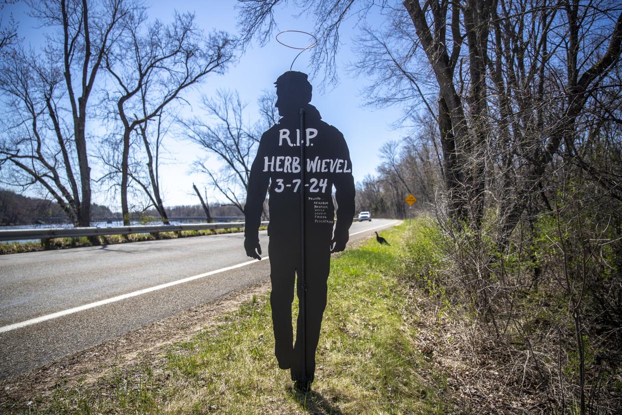 On a tight curve of West River Drive, near Portage County HH, in Stevens Point, stands a memorial to Herbert Wievel, a 63-year-old Stevens Point man who died in early March 2024, after being hit by a driver who left the scene. Neighbors placed a near life-sized pedestrian silhouette dedicated to Wievel and other signs urging people to drive safely in honor of Wievel.