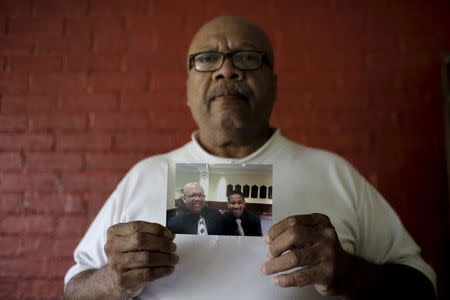 Ronald Cook, holds a photograph of him and his 20-year-old grandson Devin Cook, who was killed last year, at his home in Baltimore, Maryland July 24, 2015. REUTERS/Carlos Barria