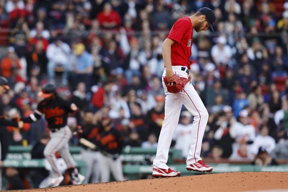 Boston Red Sox's Chris Sale looks down after giving up a 3-run home run to Baltimore Orioles' Cedric Mullins, left, during the third inning of a baseball game, Saturday, April 1, 2023, in Boston. (AP Photo/Michael Dwyer)