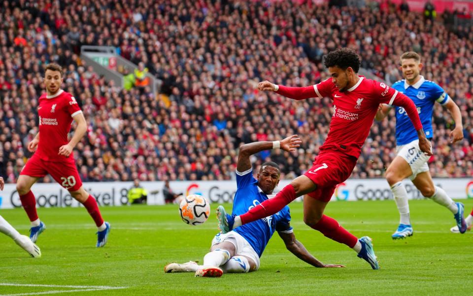 Liverpool's Luis Diaz kicks the ball ahead of Everton's Ashley Young during the English Premier League