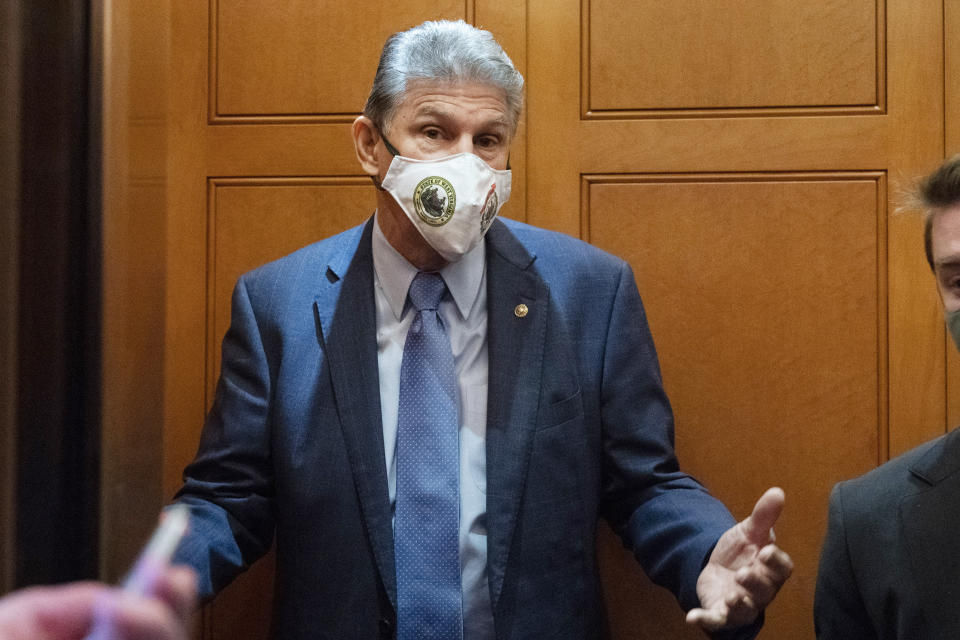 Sen. Joe Manchin, D-W.Va., a key vote on President Joe Biden's domestic spending agenda, gestures to reporters, Thursday, Dec. 2, 2021, while boarding an elevator on Capitol Hill in Washington. (AP Photo/Jacquelyn Martin)