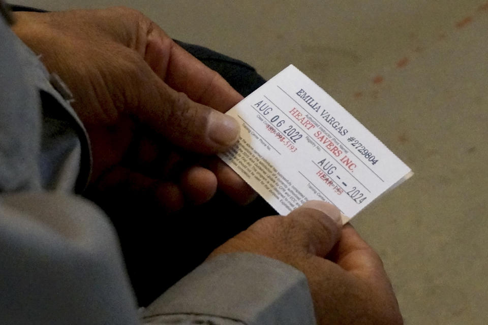 Yovani Santos, a volunteer with the rescue and recovery group Capellanes del Desierto (Desert Chaplains), holds his new CPR accreditation card, Tuesday, Sept. 6, 2022, in Tucson, Ariz. The group has received over 400 calls from families in Mexico and Central America whose relatives, sick, injured or exhausted, were left behind by smugglers in the borderlands. (AP Photo/Giovanna Dell'Orto)