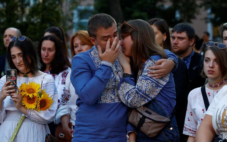 Participants dressed in traditional Ukrainian embroidered shirts react during a commemorative rally for a founder of March in Embroidered Shirts and Ukrainian serviceman Andrii Babinskyi