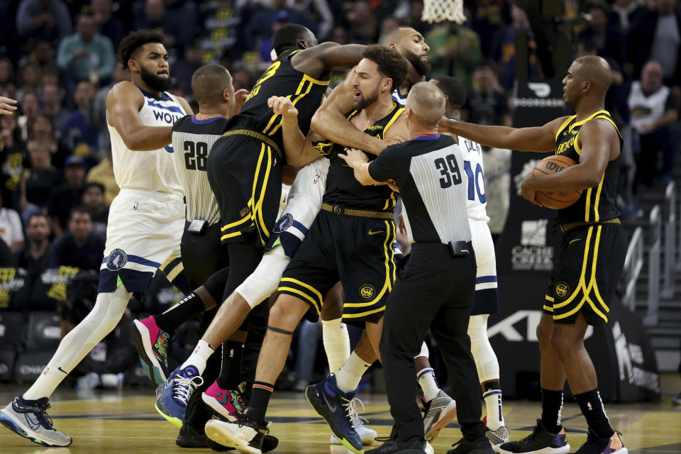 Golden State Warriors guard Klay Thompson, front, Draymond Green, left, gets into an altercation with Minnesota Timberwolves center Rudy Gobert, back, during the first half of an in-season NBA tournament basketball game in San Francisco, Tuesday, Nov. 14, 2023. They were both ejected from the game. (AP Photo/Jed Jacobsohn)