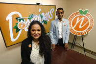 In this Thursday, May 21, 2020, photo, Jessika-Katherine Naranjo Colina, left, and Bernard Kanjoma, who co-own the graphic design and marketing firm Naranjo Designs, pose for a photo in Detroit. Kanjoma, who emigrated to the United States from Malawi, said their 12-person team has seen an 80% drop in business but they’re identifying creative ways to weather the crisis. (AP Photo/Paul Sancya)