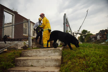 A firefighter and FEMA employee survey damage on Woodlawn Avenue following a tornado touchdown overnight in Jefferson City, Missouri, U.S. May 23, 2019. REUTERS/Antranik Tavitian