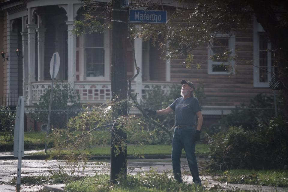 A man is see amid fallen trees.