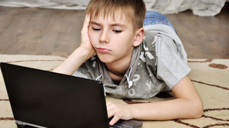 Kid looking at laptop