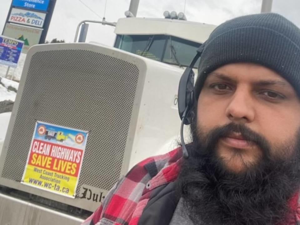 Long-distance truck driver Deep Dail stands in front of his vehicle at a gas station on Sunday. The West Coast Trucking Association is calling for more ice removal and maintenance on B.C.'s dangerous mountain highways. (Deep Dail - image credit)