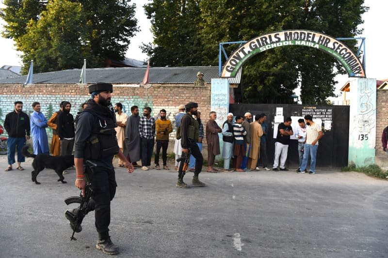 Voters queue up to cast their ballots at a polling station during the first phase of assembly elections in Pulwama. Basit Zargar/ZUMA Press Wire/dpa