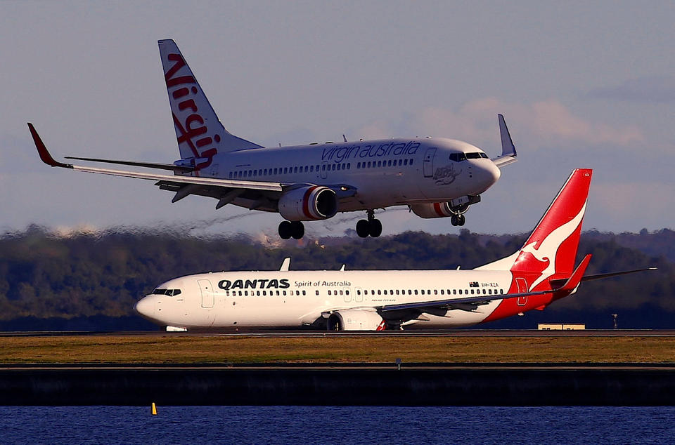 A Qantas Airways Boeing 737 plane sits on the tarmac as a Virgin Australia Boeing 737 plane lands at Sydney's Mascot Airport in Sydney, Australia July 6, 2017. REUTERS/David Gray