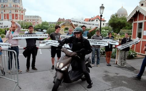 Basque activists of "No G7" hold banners reading "This is not your playground" - Credit: AP Photo/Bob Edme