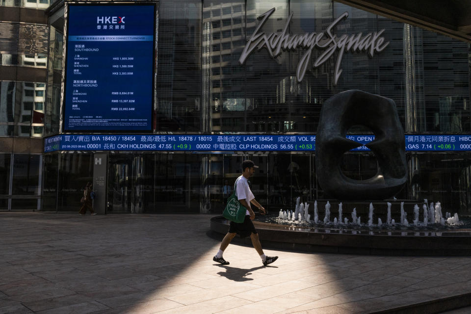 A pedestrian passes by the Hong Kong Stock Exchange electronic screen in Hong Kong, Friday, June 2, 2023. Asian stock markets followed Wall Street higher on Friday ahead of an update on the U.S. jobs market after Federal Reserve officials indicated they might skip another interest rate hike this month. (AP Photo/Louise Delmotte)