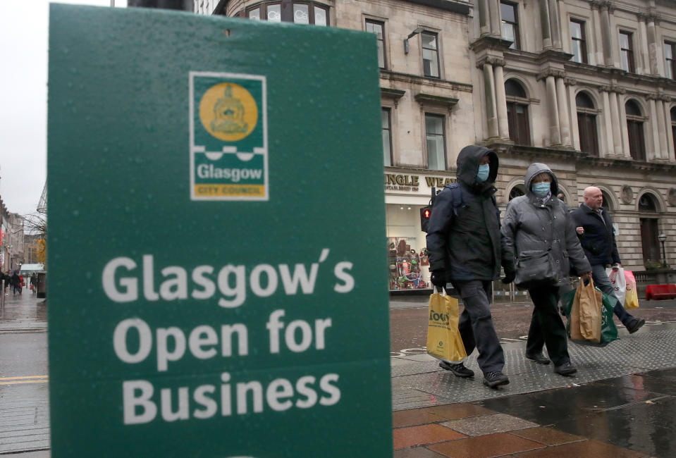 Members of the public walk passed a covid related sign in Glasgow. Parts of the west of Scotland could move into Level 4 restrictions later this week, with First Minister Nicola Sturgeon to announce her decision later today. Under the toughest restrictions, non-essential shops will be closed, along with bars, restaurants, hairdressers and visitor attractions, whilst schools remain open (Photo by Andrew Milligan/PA Images via Getty Images)