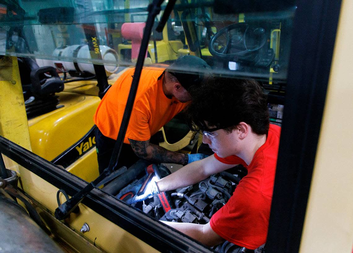 Dominic Cavallini, right, a Wake Technical Community College student, works alongside senior shop technician Joe Weimer to replace parts of a forklift at the Gregory Poole Equipment Company in Raleigh.