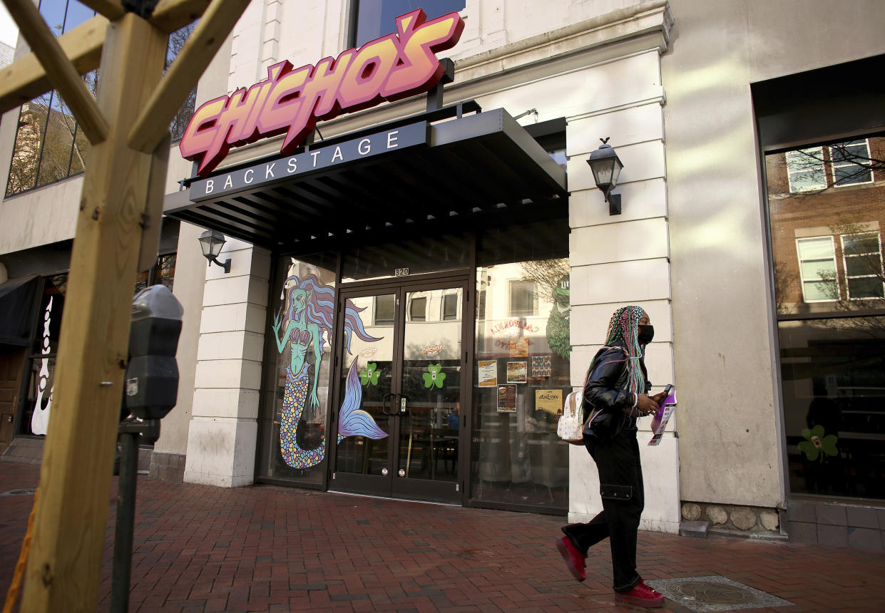 A person walks by Chicho’s Pizza Backstage, in Norfolk, Va., Saturday, March 19, 2022, where a fatal shooting took place outside the restaurant and bar earlier in the day. Newspaper reporter Sierra Jenkins was one of the people killed during the shooting after getting caught in the crossfire. (Stephen M. Katz/The Virginian-Pilot via AP)