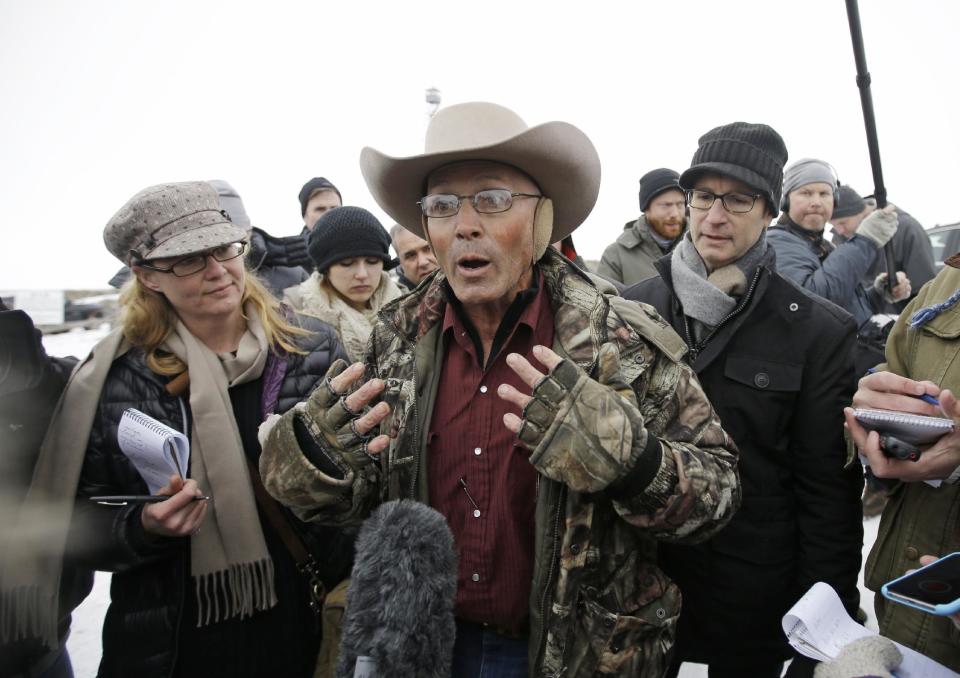 FILE - In this Jan. 5, 2016 file photo, LaVoy Finicum, middle, a rancher from Arizona, talks to reporters at the Malheur National Wildlife Refuge near Burns, Ore. Finicum's widow, Jeanette Finicum, and their children are planning to hold a meeting in John Day, Ore., Jan. 28, 2017, in an effort to continue with his mission. (AP Photo/Rick Bowmer, file)