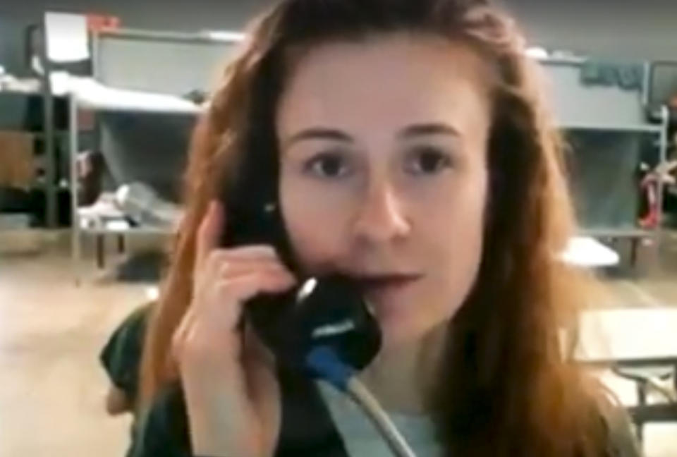 In this image taken from video, Maria Butina speaks on a phone in a dormitory with bunk beds in Chickasha, Oklahoma, USA. Butina, a Russian gun rights activist, who is serving a U.S. prison sentence for acting as an unregistered foreign agent, has released a video asking for money to help pay her legal costs. (Alexander Ionov via AP)