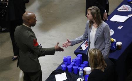 A U.S. Marine (L) shakes hands at an employers booth at the Hiring Our Heroes job fair in Washington January 10, 2014. REUTERS/Kevin Lamarque