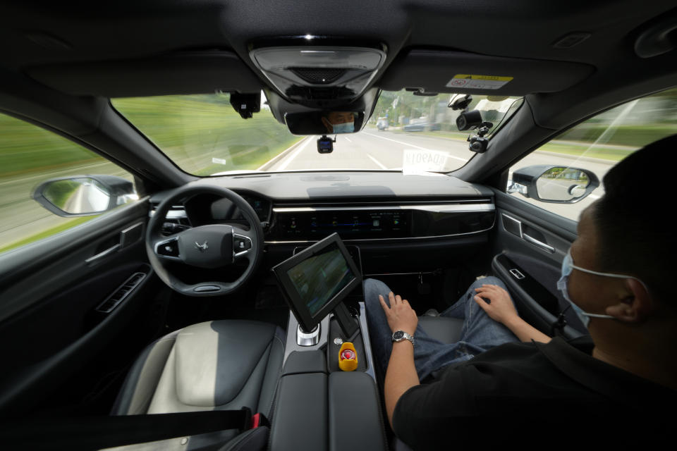 A technician monitors the self-driving taxi developed by tech giant Baidu Inc. on June 14, 2022, in Beijing. Baidu Inc. is China's highest-profile competitor in a multibillion-dollar race with Alphabet Inc.'s Waymo and General Motors Co.'s Cruise to create self-driving cars. (AP Photo/Ng Han Guan)