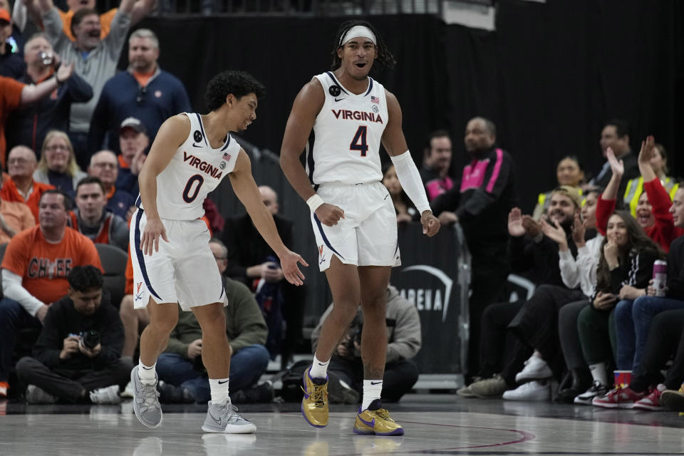 Virginia's Armaan Franklin (4) and Kihei Clark (0) celebrate after a play against Illinois during the second half of an NCAA college basketball game Sunday, Nov. 20, 2022, in Las Vegas. (AP Photo/John Locher)