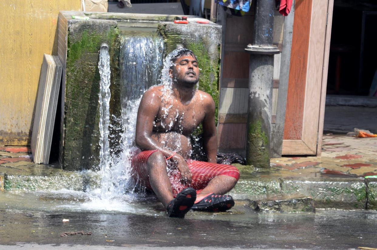 Un hombre se refresca con agua por el calor extremo Saikat Paul / Shutterstock