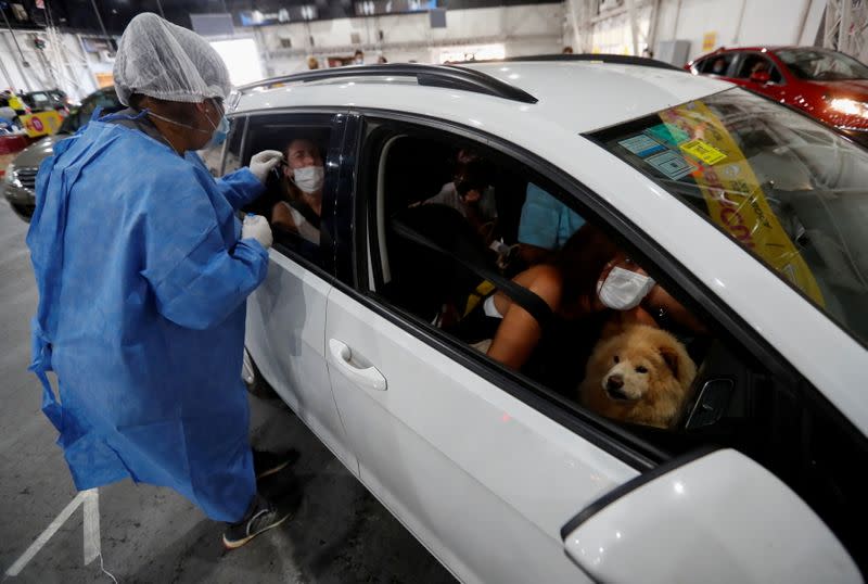 Un trabajador sanitario toma una muestra de hisopo de una niña para comprobar la enfermedad del coronavirus (COVID-19), en Buenos Aires, Argentina.