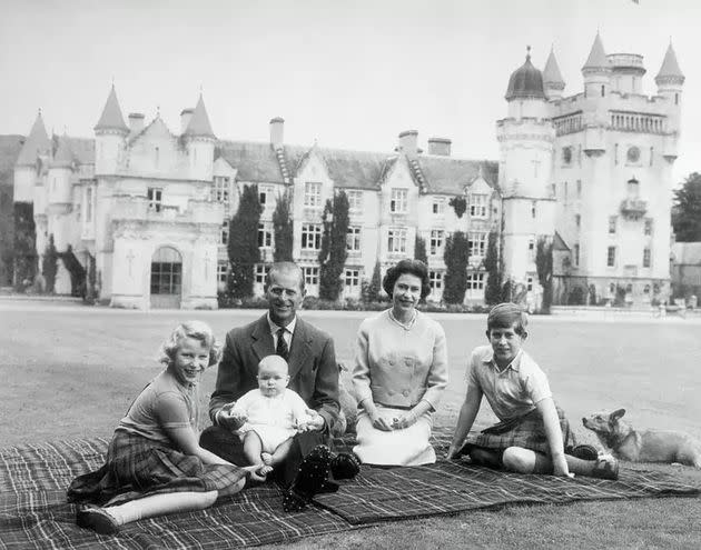 El príncipe Andrés en el regazo del príncipe Felipe de Edimburgo durante un picnic en los terrenos del Castillo de Balmoral. También aparecen la reina Isabel, el príncipe Carlos y la princesa Ana. (Photo: getty)
