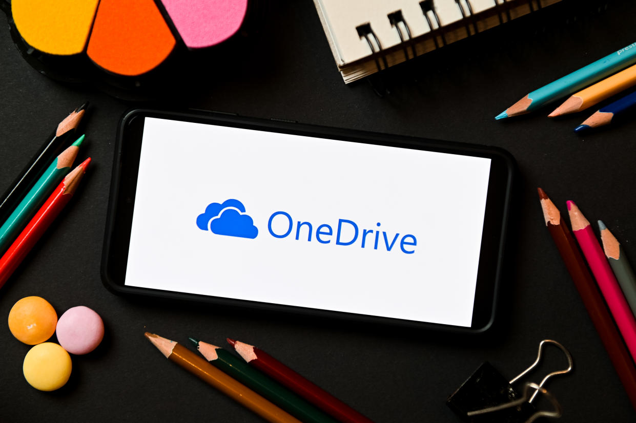  OneDrive logo on a smartphone in front of stationary 