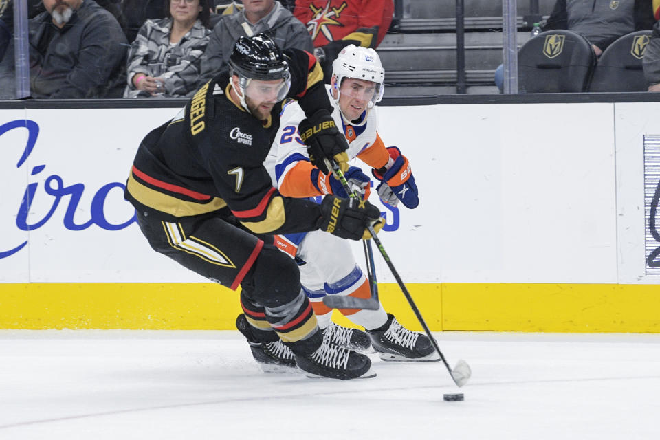 Vegas Golden Knights defenseman Alex Pietrangelo (7) and New York Islanders center Brock Nelson (29) fight for the puck during the first period of an NHL hockey game Saturday, Dec. 17, 2022, in Las Vegas. (AP Photo/Sam Morris)