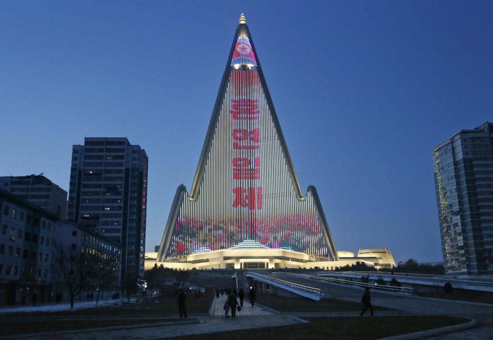 En esta foto del 20 de diciembre de 2018, se muestra un mensaje de propaganda en la fachada del hotel Ryugyong. Transformado en el telón de fondo para una gigantesca exhibición de propaganda, el Ryugyong Hotel de 105 pisos de la capital, aún por completar, es una vez más el tema de Corea del Norte. En un brillante giro del guión, el edificio deshabitado y piramidal que se eleva sobre la capital del norte ha sido adornado con más de 100,000 luces que durante varias horas todas las noches transmiten propaganda por todas partes. (Foto AP / Dita Alangkara)