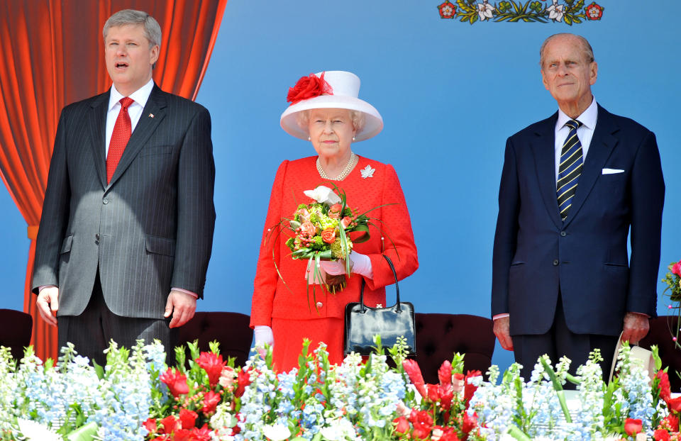 OTTAWA, ON - JULY 01: Queen Elizabeth II stands next to Canadian Prime Minister Stephen Harper and Prince Phillip, Duke of Edinburgh, in the Royal box outside the Canadian Parliament, during the Canada Day celebrations on July 1, 2010 in Ottawa, Canada. The Queen and Duke of Edinburgh are on an eight day tour of Canada starting in Halifax and finishing in Toronto. The trip is to celebrate the centenary of the Canadian Navy and to mark Canada Day. On July 6th the Royal couple will make their way to New York where the Queen will address the UN and visit Ground Zero. (Photo by John Stillwell-Pool/Getty Images)