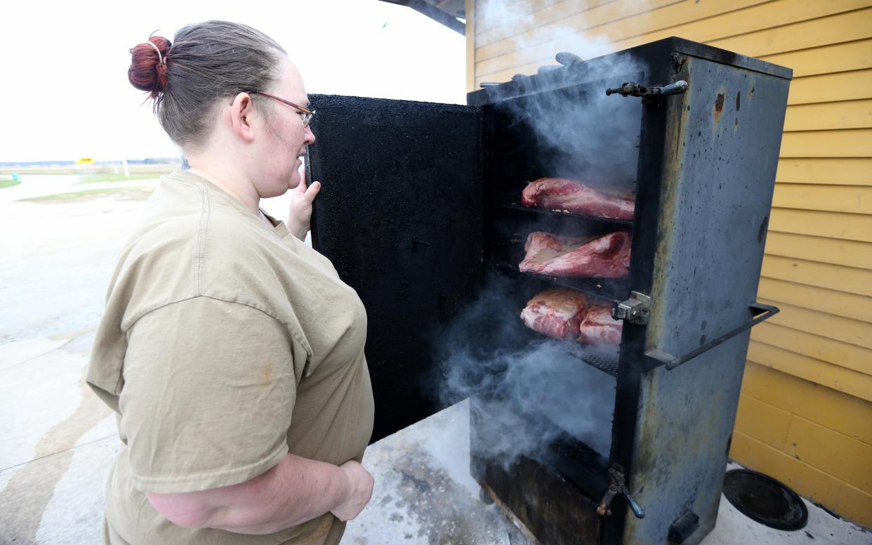 Chef Sarah Martin checks on the smoker where brisket, pastrami and pork are being prepared Thursday, March 28, 2024, at Kate O’Connor’s Irish Pub on East Michigan Street in New Carlisle.