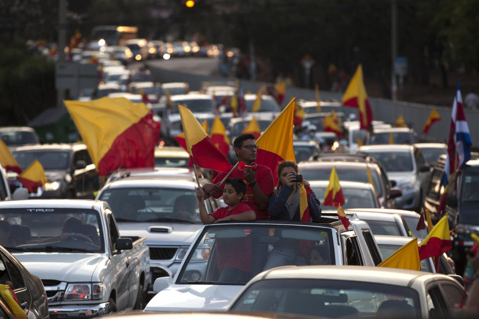 Seguidores de Luis Guillermo Solís, candidato presidencial del Partido Acción Ciudadana, PAC, opositor, ondean banderas partidistas en una caravana de vehículos tras el cierre de la votación de la segunda ronda electoral en San José, Costa Rica, el domingo 6 de abril de 2014.(AP Photo/Moises Castillo)