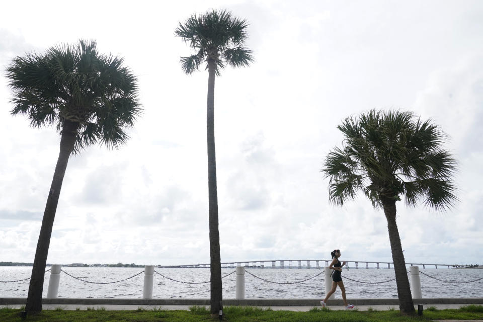 A jogger runs along a sea wall, Monday, Sept. 26, 2022, in Miami. States are spending billions of dollars of federal pandemic relief funds on infrastructure projects such as roads, bridges and public buildings. The American Rescue Plan law signed by President Joe Biden last year provided $350 billion to states and local governments to respond to the coronavirus and shore up their economies. (AP Photo/Marta Lavandier)