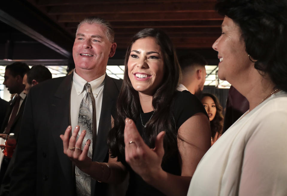 Washington guard Kelsey Plum, center, speaks to a television crew alongside her father, Jim, left, and mother, Katie, before the WNBA basketball draft, Thursday, April 13, 2017, in New York. (AP Photo/Julie Jacobson)