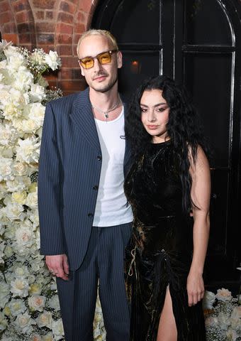 <p>David M. Benett/Jed Cullen/Dave Benett/Getty</p> George Daniel and Charli XCX attend the Vogue & Netflix party in London in May 2023
