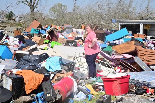 A woman sorts through belongings at a storage facility in Amory after an overnight tornado caused widespread damage.
