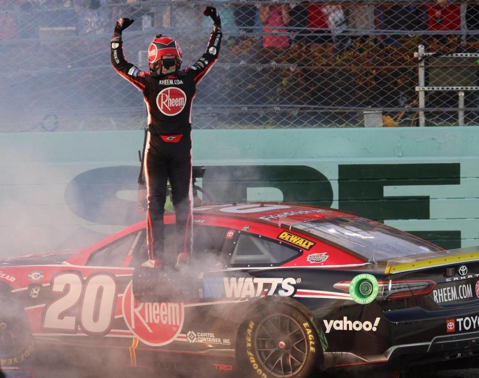 Christopher Bell stands on his car and lift his arms after winning the NASCAR 4EVER 400 Cup Series on Sunday, Oct. 22, 2023, at Homestead-Miami Speedway in Homestead, FL. Carl Juste/cjuste@miamiherald.com