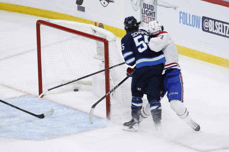 Winnipeg Jets' Mark Scheifele (55) hits Montreal Canadiens' Jake Evans (71) after Evans scored an empty-net goal during the third period of Game 1 of an NHL hockey Stanley Cup second-round playoff series Wednesday, June 2, 2021, in Winnipeg, Manitoba. (John Woods/The Canadian Press via AP)