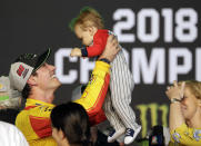 Joey Logano holds his son Hudson after winning the NASCAR Cup Series Championship auto race at the Homestead-Miami Speedway, Sunday, Nov. 18, 2018, in Homestead, Fla. (AP Photo/Lynne Sladky)