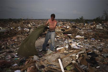 Eddie Taylor pulls a blanket out of the rubble of his childhood home in Moore, Oklahoma, four days after the Oklahoma City suburb was left devastated by a tornado in this May 24, 2013 file photo. REUTERS/Adrees Latif/Files