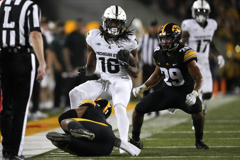 Michigan State wide receiver Christian Fitzpatrick (16) is tackled by Iowa defensive back Xavier Nwankpa (1) and defensive back Sebastian Castro (29) after catching a pass during the first half of an NCAA college football game, Saturday, Sept. 30, 2023, in Iowa City, Iowa. (AP Photo/Charlie Neibergall)