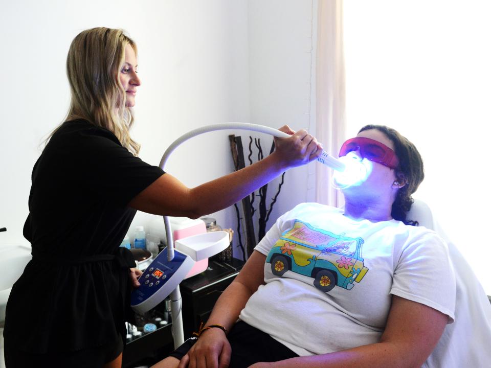 Nicole Armstrong performs teeth whitening in her suite at The Design Studio Salon and Spa in Zanesville. Armstrong is one of five partners at the full-service salon, located on Adair Avenue, all of whom have private work areas. 