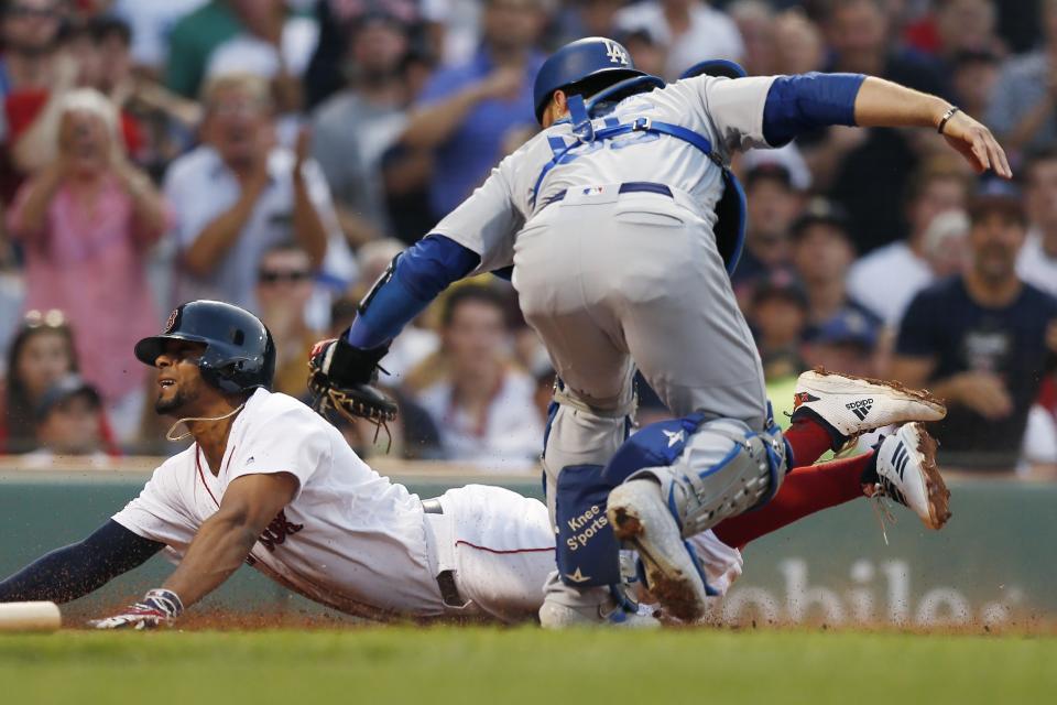 Boston Red Sox's Xander Bogaerts, left, scores against Los Angeles Dodgers' Russell Martin, right, during the first inning of a baseball game in Boston, Sunday, July 14, 2019. (AP Photo/Michael Dwyer)