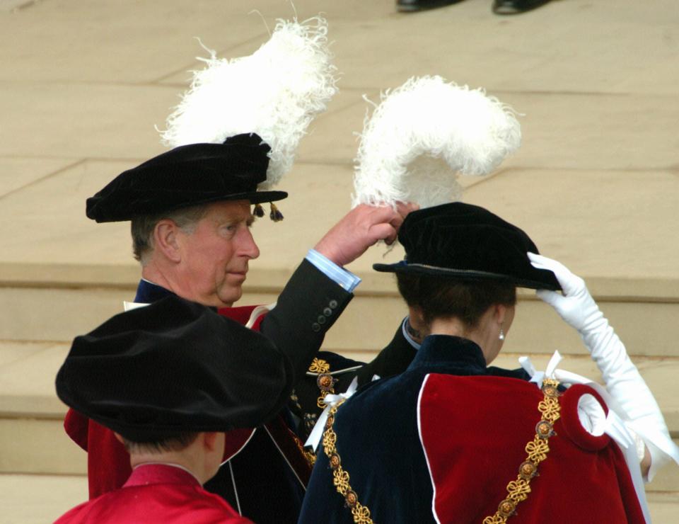 Prince Charles adjusts Princess Anne's plume at Windsor Castle on June 13, 2005.