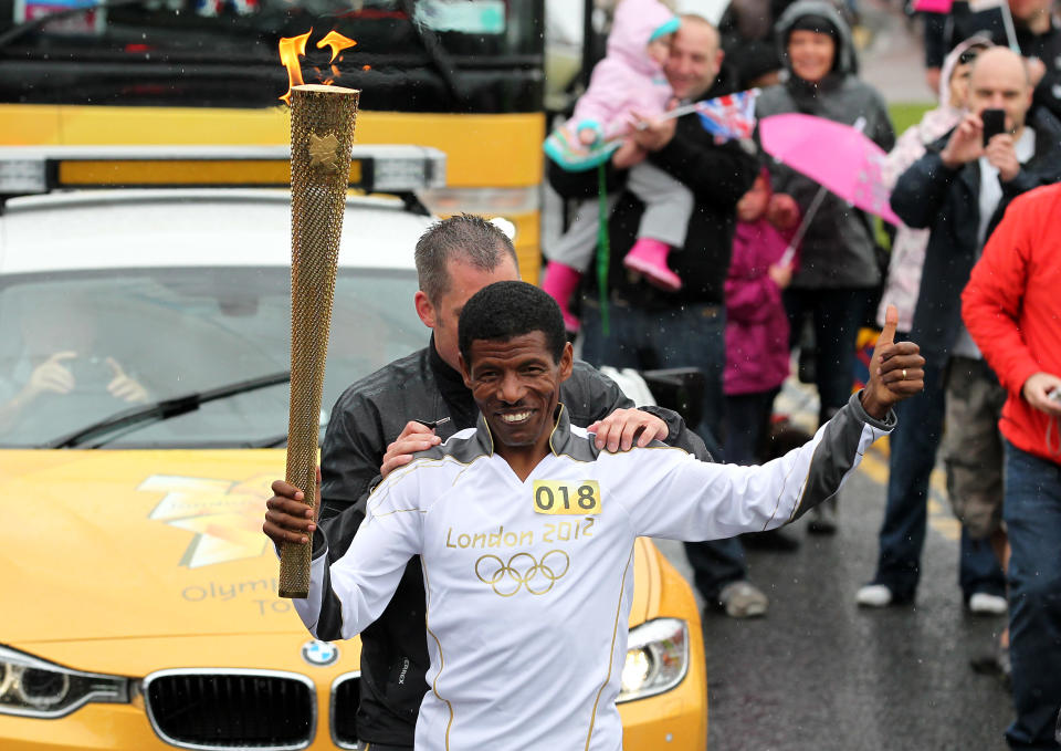 In this handout image provided by LOCOG, Torchbearer Haile Gebrselassie carries the Olympic Flame on the Torch Relay leg between Gateshead and South Shields on June 16, 2012 in Gateshead, England. The Olympic Flame is now on day 29 of a 70-day relay involving 8,000 torchbearers covering 8,000 miles. (Photo by LOCOG via Getty Images)