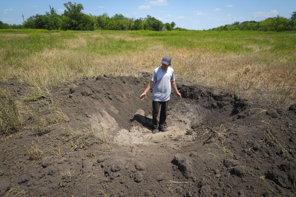 Farmer Serhiy, a local grain producer, shows a crater left by a Russian shell on his field in the village of Ptyche in eastern Donetsk region, Ukraine, Sunday, June 12, 2022. Serhiy claims he cannot sell his grains because nobody wants to come to the area which has been under Russian shelling. Ukraine is one of the world’s largest exporters of wheat and corn but Russia's invasion and a blockade of its ports have halted much of that flow. (AP Photo/Efrem Lukatsky)