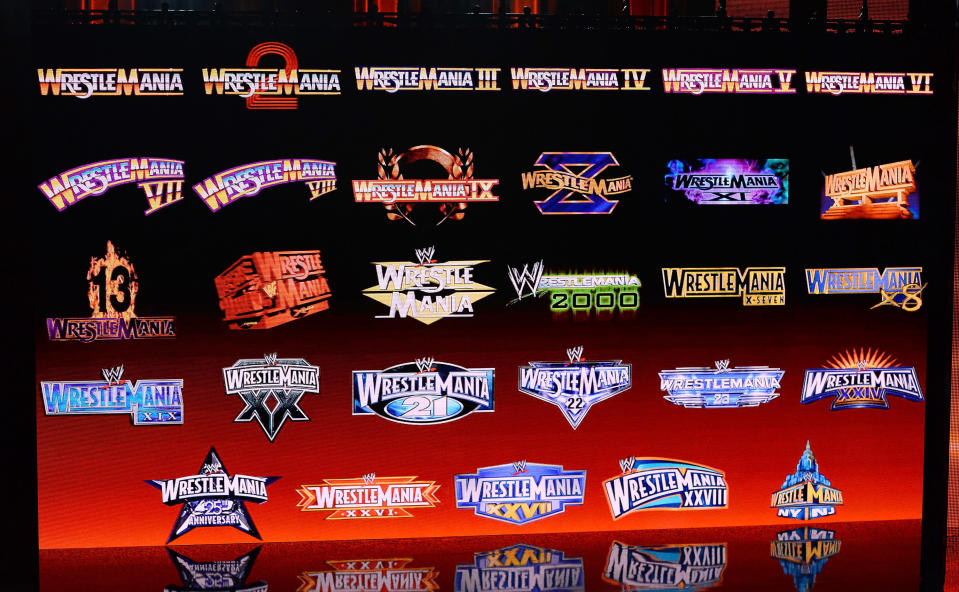 WrestleMania logos from past years are displayed on a screen during a news conference announcing the WWE Network at the 2014 International CES — Getty Images