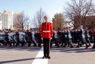 A soldier stands at attention as others march toward the memorial during Remembrance Day ceremonies at the National War Memorial in Ottawa November 11, 2014. REUTERS/Chris Wattie